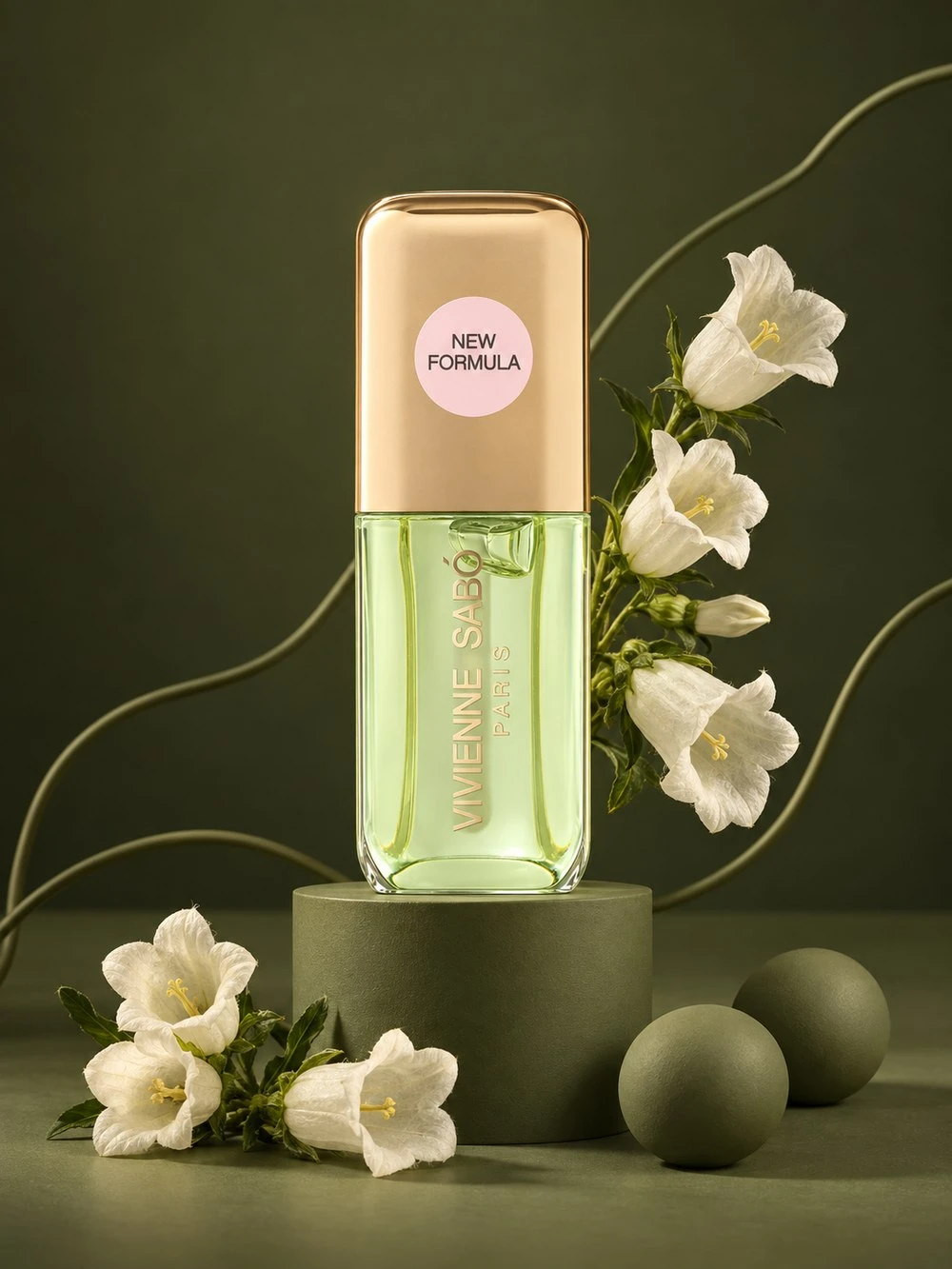Vivienne Sabó fragrance on an olive podium, surrounded by white flowers and sculptural green forms